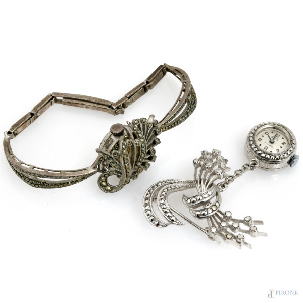 Lotto composto da 1 bracciale con orologio e una spilla con orologio in argento e strass, XX secolo, misura max cm 5,5x4