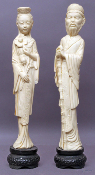 Coppia di sculture in resina raffiguranti fior di loto e santone, H 32 cm.