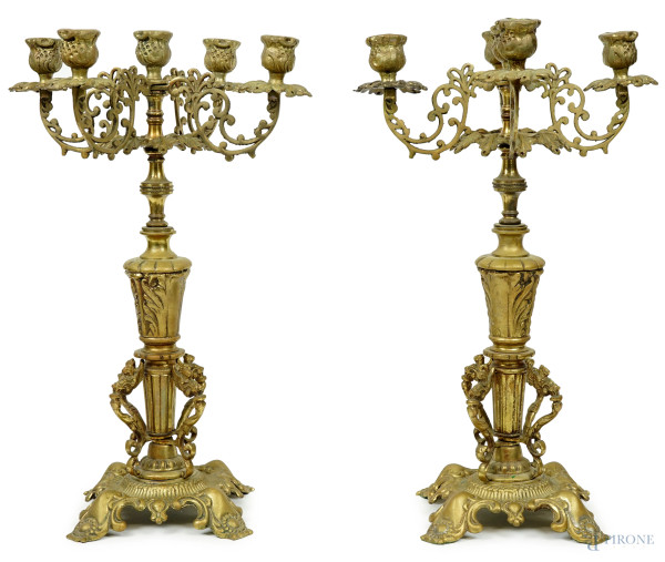 Coppia di candelabri in bronzo a cinque fiamme, XX secolo, bracci a volute, fusto a balaustro poggiante su base quadrangolare, cm h 43,5