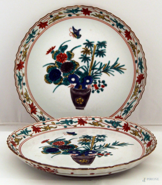 Coppia di piatti in porcellana a decoro di vasi e fiori con bordo decorato, diam. 22 cm