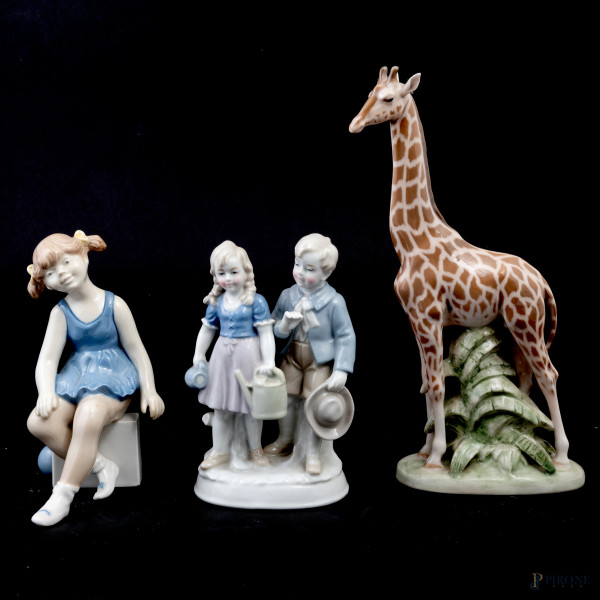 Lotto di tre sculture raffiguranti bambini e giraffa in porcellana policroma di vari marchi, XX secolo, altezza massima cm 24,5, (segni di usura, piccole sbeccature)