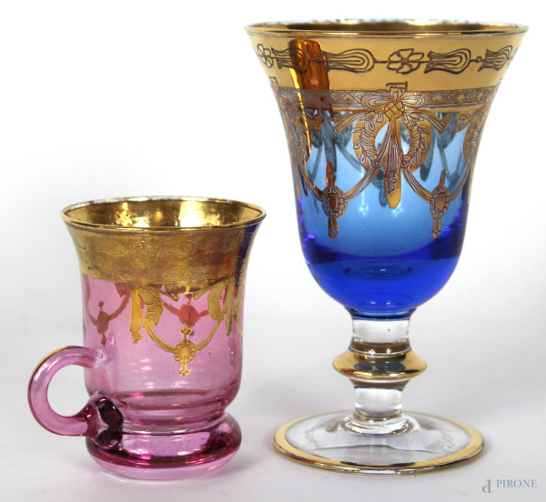 Lotto di un calice ed un bicchierino in vetro nei toni del blu e del rosa, decori dorati, altezza max cm. 14,5