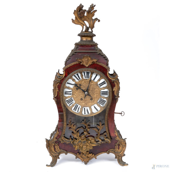 Pendola da tavolo con cassa in legno impiallacciato con inserti in bronzo cesellato a motivi vegetali. Quadrante circolare in bronzo dorato e cesellato a numeri romani smaltati. XX secolo, cm 69,5x35,5x14 (da revisionare, cadute di impiallacciatura, difetti)