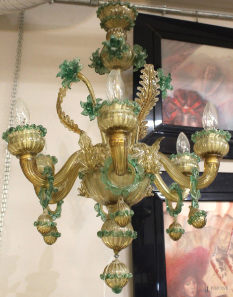 Lampadario in vetro soffiato di Murano, a un ordine di braccia ricurve per complessive sei luci alternate a foglie e fiori, profilature in pasta vitrea verde, cm h 67