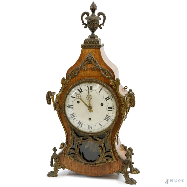 Orologio da tavolo stile Luigi XV, cassa in legno, quadrante circolare in  metallo brunito a numeri romani, sormontato da vaso con fiamma, particolari a volute e quattro piedini ferini,  cm h  82x43,5,x15, (meccanismo da revisionare)