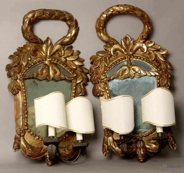 Coppia di appliques a specchio a due luci in legno intagliato e dorato a mecca, XVIII se, h. 65 cm.