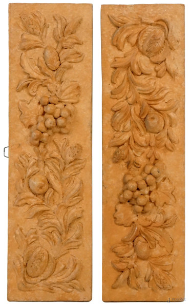 Coppia di fregi in terracotta con decoro di frutti a altorilievo, cm 42x12,5, XX secolo, (difetti).