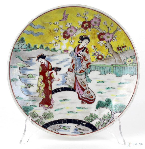 Piatto in porcellana policroma, decorato con paesaggio e figure femminili, diametro cm. 25, Giappone, XX secolo.