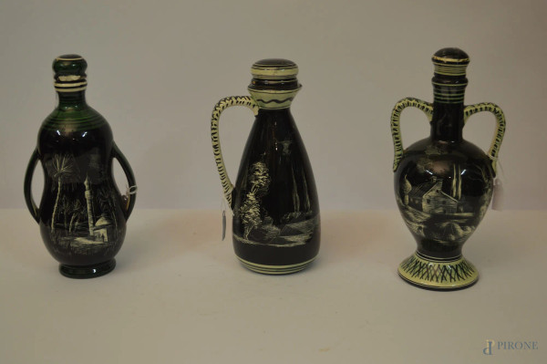 Lotto composto da tre bottigliette in maiolica scura a decoro di paesaggi, marcati Marmaca Repubblica di San Marino anni &#39;50, h. max 23 cm.