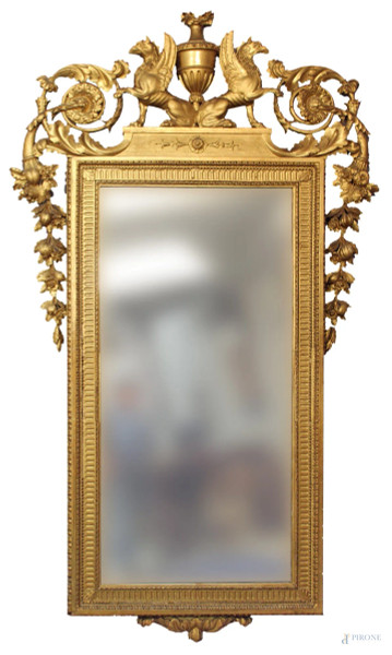 Specchiera in legno dorato con laterali a motivi di frutti e foglie d&#39;acanto, cimasa con due grifoni e vaso con fiori, XIX sec., cm 222 x 128.