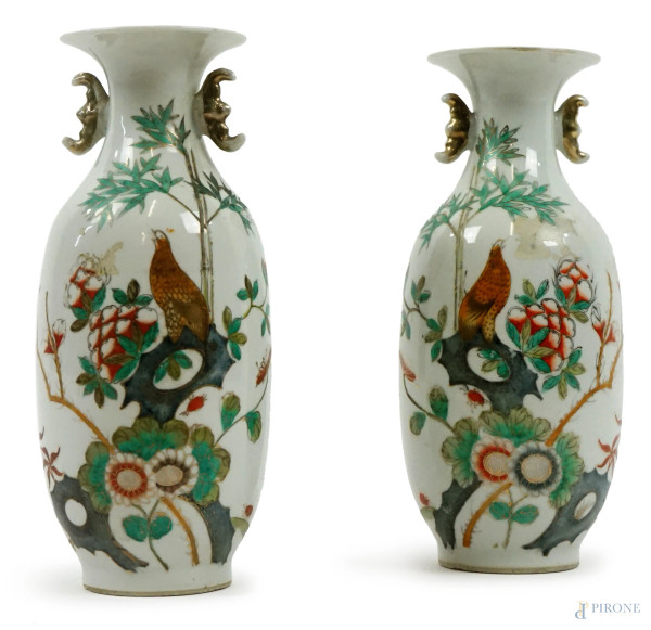 Coppia di vasi in porcellana, Cina, XX secolo, decoro policromo raffigurante fiori e volatili, iscrizioni al retro, cm h 21,5, (difetti)