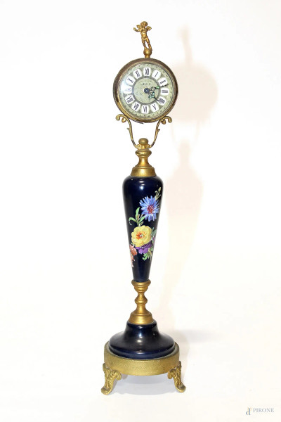 Orologio in porcellana dipinta base in ottone, h 33 cm.