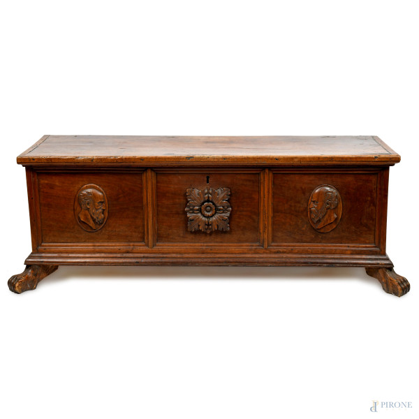 Cassapanca in noce modanato con fronte scandito da tre sezioni contenenti rispettivamente al cent...