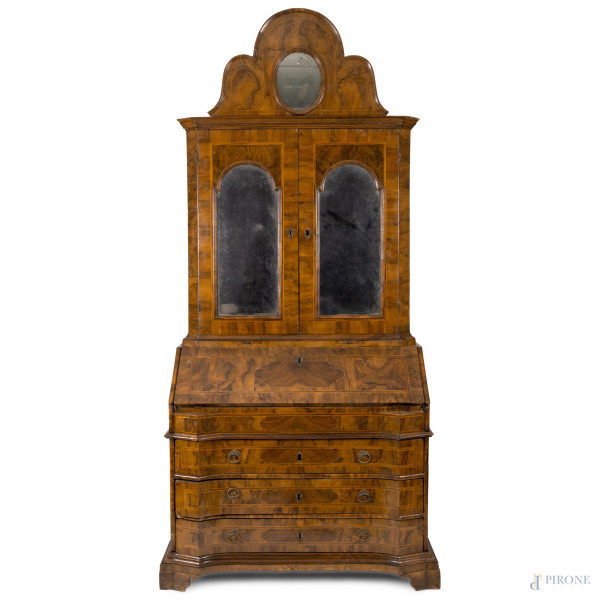 Trumeau in legno impiallacciato in radica. Fronte scandito da tre cassetti in colonna sormontati da calatoia con vano scrittoio. Corpo superiore a doppia anta vetrata celante 4 ripiani.  XX secolo, cm 254x120x56, (segni di usura, difetti, graffi, scalfiture) 