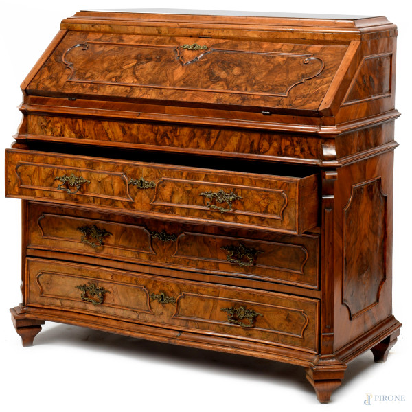 Ribalta in noce e radica, fronte scandito da tre cassetti con maniglie bronzee sormontati da spor...