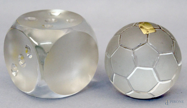 Lotto composto da due fermacarte in vetro a forma di dado e pallone, h. 7 cm.