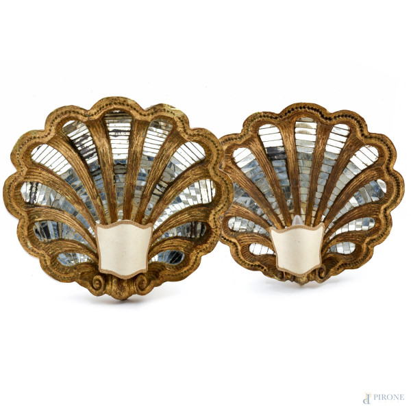 Coppia di appliques a unica luce in legno dorato e intagliato a foggia di conchiglia con inserti in specchio, XX secolo, cm 46x50x10, (segni di usura, scalfiture, cadute di doratura, difetti, rotture)