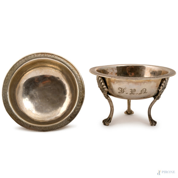 Coppia di salierine in argento cesellato poggianti su tre piedini, una recante inziali incise, XX secolo, XIX-XX secolo, altezza cm 5, peso totale gr. 130