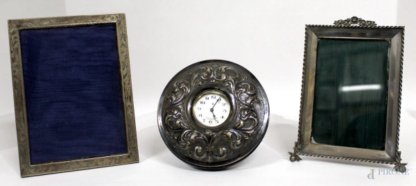Lotto composto da due cornicette portafoto in argento, cm 21 x 16, ed un orologio da tavolo rivestito in argento, H 16 cm.