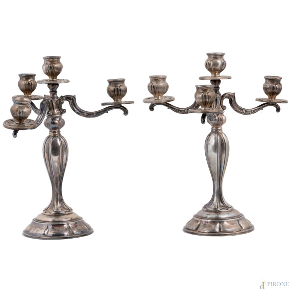 Coppia di candelabri a quattro luci in argento 800/000, altezza cm 29, peso lordo complessivo gr 760, (segni di usura, rotture)
