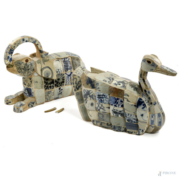 Lotto di due sculture raffiguranti anatra ed elefante in mescola di gesso e cemento rivestita in tasselli in maiolica decorata nei toni del blu, XX secolo, misure massime cm 25x38x12, (segni di usura, scalfiture, rotture, difetti)