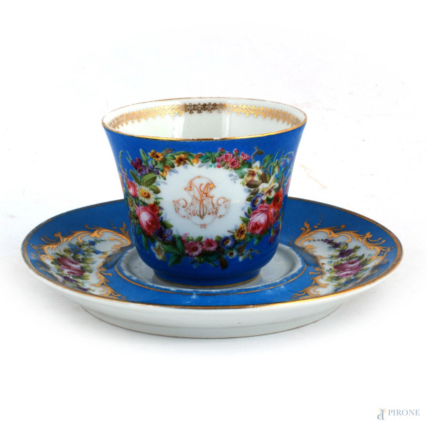 Lotto composto da tazza e piattino in porcellana dipinta nei toni del blu con decori floreali, XX secolo, altezza tazza cm 8,5, diametro piatto cm 20, (segni di usura)