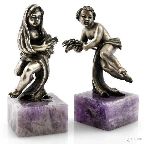 Coppia di sculture raffiguranti allegorie dell'inverno e dell'estate in argento su base in ametista, XX secolo, altezza cm 8,5, peso complessivo lordo gr 373, (lievi segni di usura)