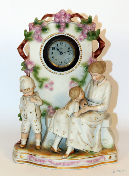 Orologio da tavolo in bisquit a decoro fiori e personaggi a rilievo, h. cm 28.