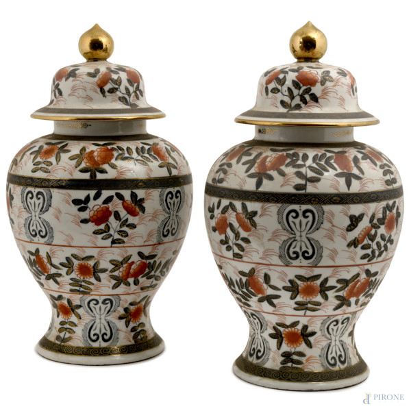 Coppia di potiche in porcellana bianca con decorazioni a motivi floreali. Presa a pomo dorato.  Cina, XX secolo, altezza complessiva cm 42, (difetti)