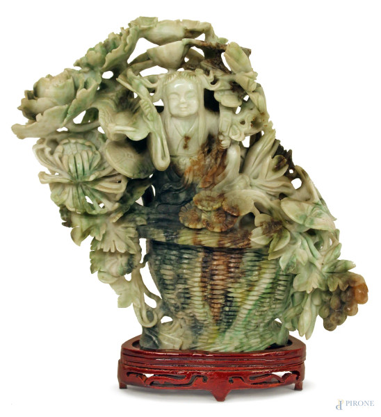 Scultura in giadeite, raffigurante figura circondata da fiore, base in legno, H. 23 cm., Cina XIX sec.