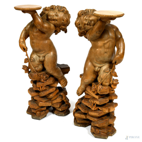 Lotto di due sculture in legno raffiguranti putti, altezza massima cm 94, firmate e datate alla base, (segni di usura, scalfiture, difetti) 