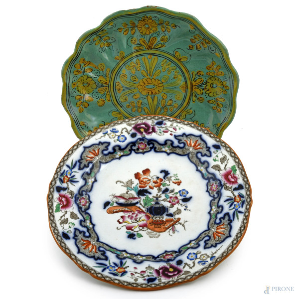 Lotto di due piatti in maiolica di diversa manifattura e foggia, XX secolo, diametro massimo cm 25, (scalfiture, difetti di cottura, cadute di smalto)
