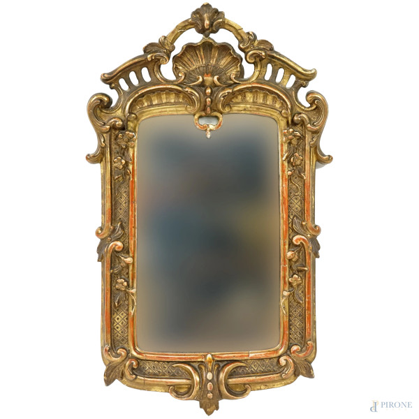 Specchiera in legno intagliato e dorato, XX secolo, cimasa intagliata a conchiglia e traforo, laterali a ricciolo, cm h 52x32,5, (difetti)
