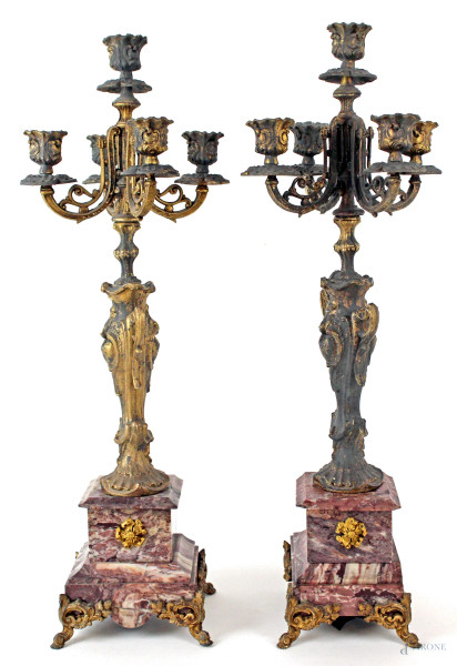 Coppia di candelabri in metallo dorato, a cinque luci, con base di marmo rosa, altezza cm.54,5, fine XIX secolo, (difetti e parti rotte).