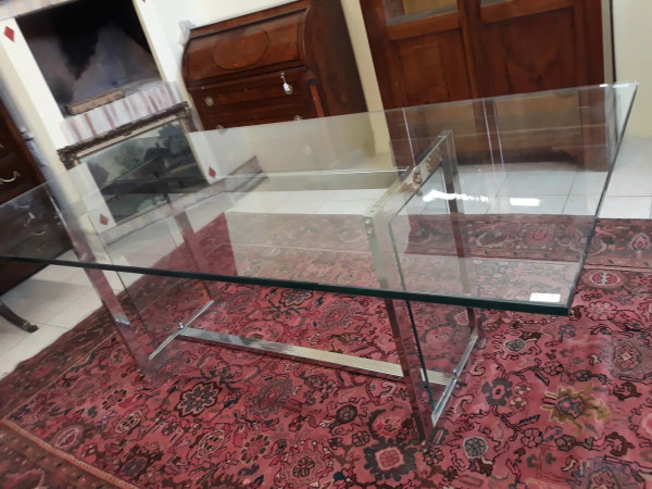Tavolo in cristallo, poggiante su base in ferro, (lievi difetti sul vetro laterale), h.77x216x100 cm.