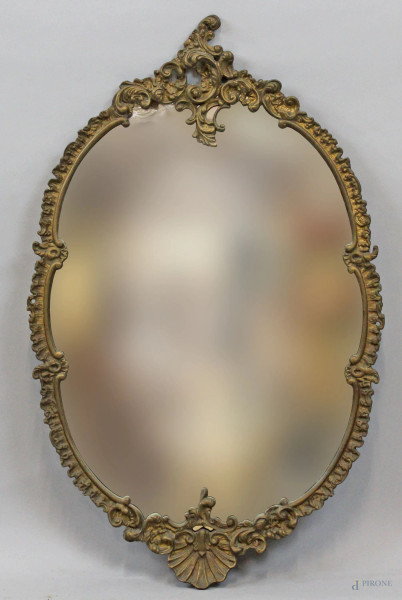 Specchiera di linea ovale centinata in metallo cesellato e dorato, XX secolo, cm 74x46