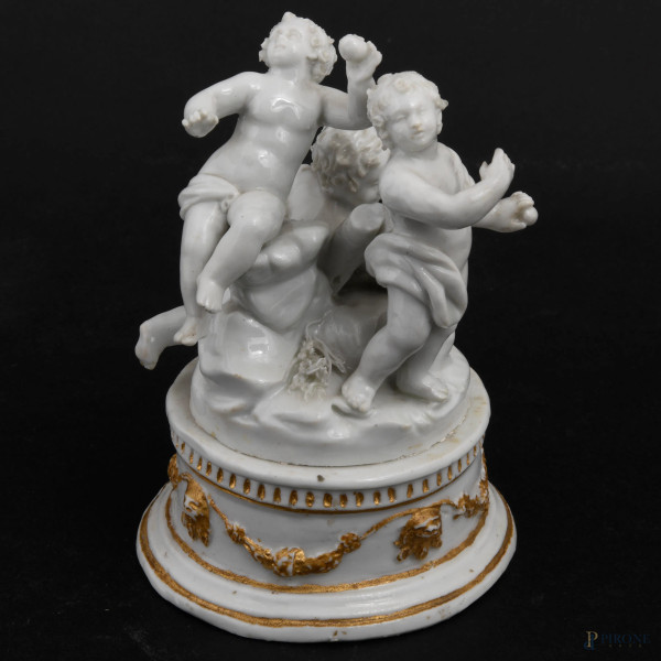 Gioco di putti,in porcellana, XVIII secolo, base circolare decorata con festoni dorati a rilievo, cm 14x11, (difetti)