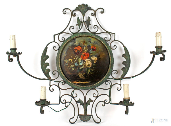 Applique in ferro battuto a quattro luci, medaglione centrale con fiori dipinti, altezza cm 56,5, prima metà XX secolo