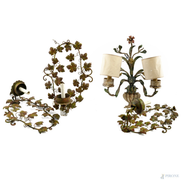 Lotto di tre appliques a singola luce in ferro battuto a foggia di racemi vegetali e un' applique in ferro battuto a due luci a foggia di cratere contenente racemi fioriti, XX secolo, misure massime cm 61x46x17 ca., (segni di usura, difetti, da revisionare)