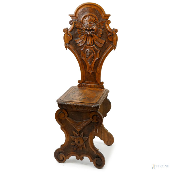 Sedia Neorinascimento, XIX secolo, in legno di noce intagliato e scolpito, schienale ad asso di coppe centrato da mascherone e scudetto, gambe sagomate, cm h 114