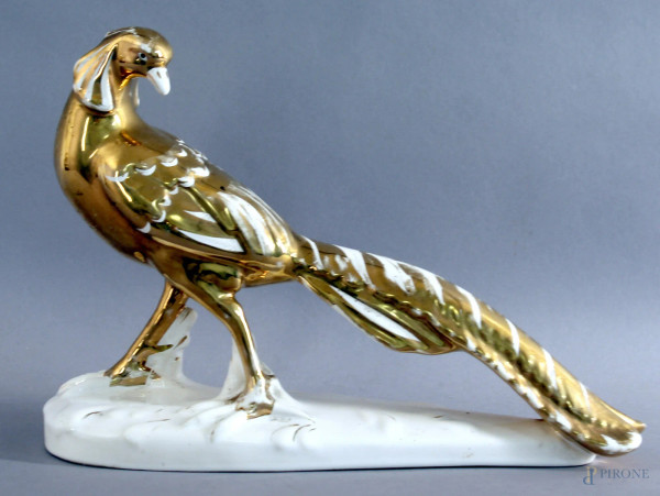 Volatile, scultura in maiolica bianca e dorata, marcata sotto la base, altezza 22 cm, lunghezza 31 cm.