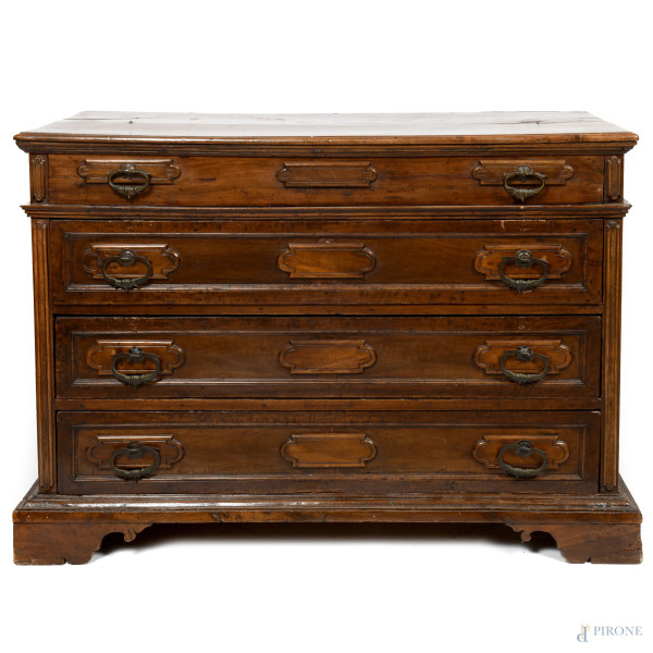 Cassettone in noce con fronte scandito da tre cassetti e finto cassetto. Piano superiore apribile...