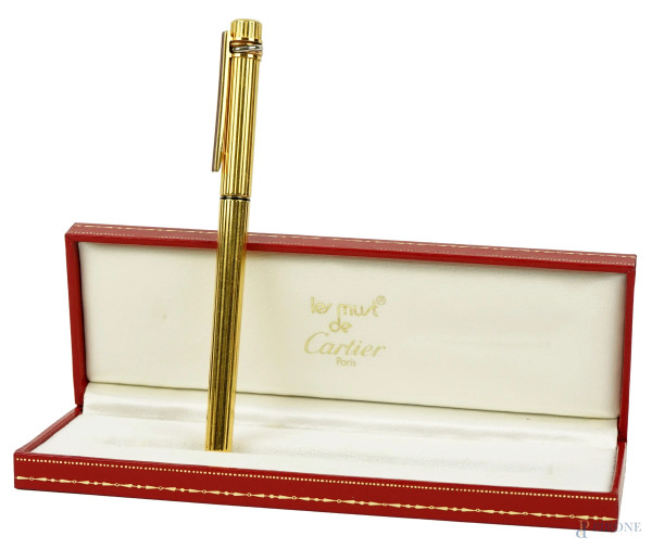 Must de Cartier, penna a sfera in metallo dorato entro astuccio originale, lunghezza cm 13,5, completo di certificato di garanzia.
