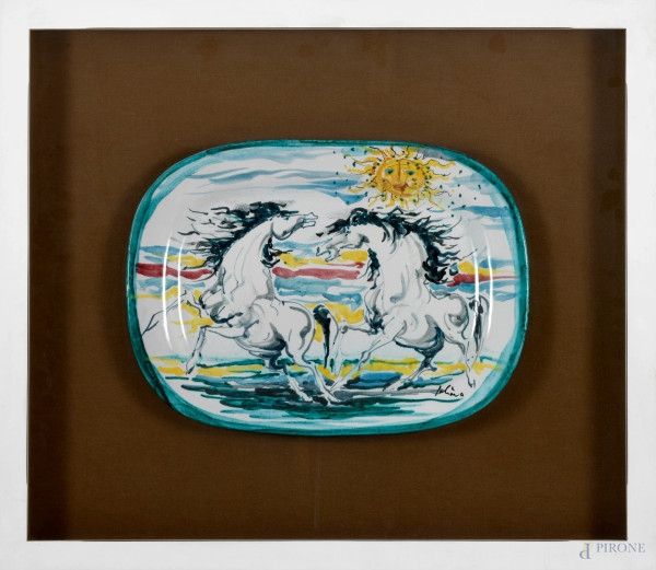 Piatto in ceramica San Giorgio Albisola raffigurante lotta tra cavalli,  firmato in basso a destra, cm 30x41 entro cornice a bacheca (cm 59x68)