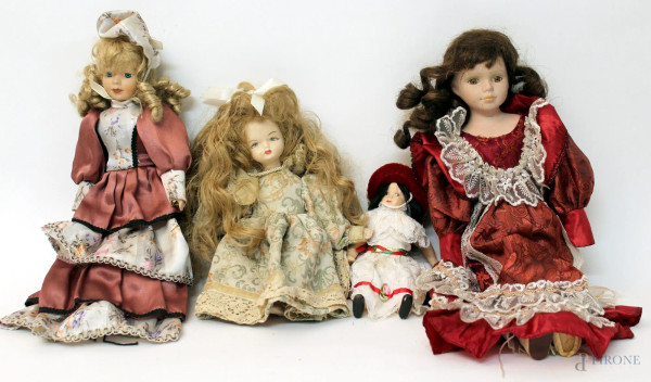 Lotto composto da quattro bambole in porcellana, vestiti in tessuto.