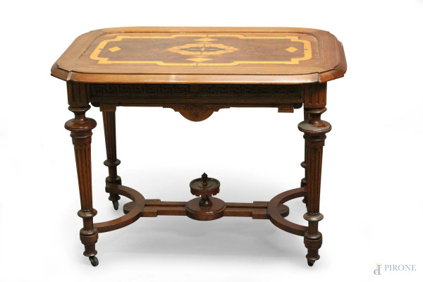 Tavolino da salotto in noce con piano intagliato a vari legni pregiati, poggiante su quattro gambe scanalate legate da crociata, cm 70 x 64 x 96.
