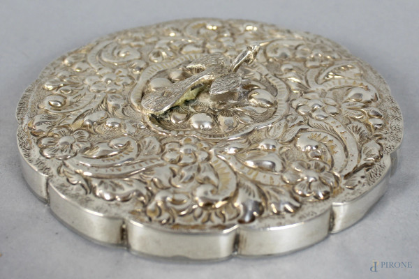 Specchietto di linea tonda centinata in argento sbalzato e cesellato con volatile a rilievo, arte orientale, diametro 12 cm.