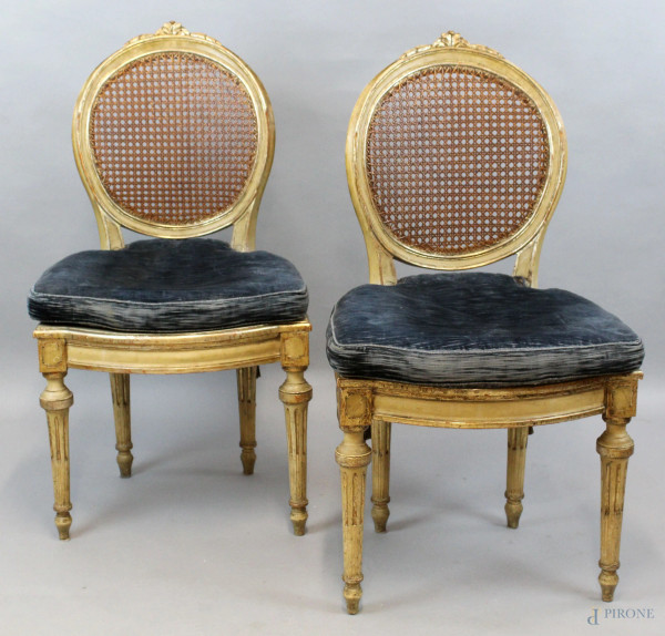 Coppia di sedie in legno laccato e dorato, sedute e schienali in cannetè, gambe rastremate e scanalate, cuscini in velluto blu, (difetti)