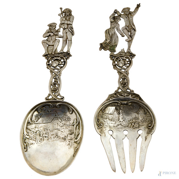 Lotto di due posate da portata in argento finemente cesellato con prese raffiguranti popolani che suonano e che danzano e cesello a motivi di paese. Manifattura francese, 1768, cm 23x7,5, peso complessivo gr200