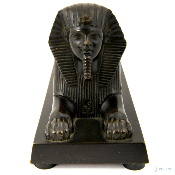 Scultura in metallo brunito su base rettangolare, inserita all'interno di teca in plexiglass con ...